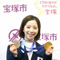 二つのメダルを手に笑顔を見せる三浦璃来選手＝宝塚市で、梅田麻衣子撮影