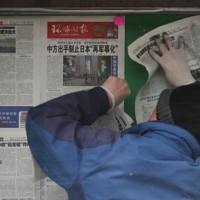 中国政府が対日禁輸リストを発表したことを1面で報じる中国の新聞を掲示板に張り出す作業員＝北京市で2026年2月25日、AP