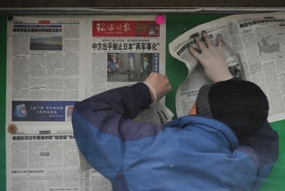中国政府が対日禁輸リストを発表したことを1面で報じる中国の新聞を掲示板に張り出す作業員＝北京市で2026年2月25日、AP