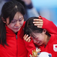連覇を逃した女子団体追い抜きのフラワーセレモニー後、涙が止まらない高木菜那（右）を抱き寄せる高木美帆＝北京・国家スピードスケート館で2022年2月15日、貝塚太一撮影