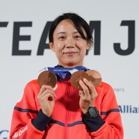 記者会見で、メダルを手に笑顔を見せる高木美帆＝イタリア・ミラノで2026年2月21日、吉田航太撮影