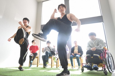 生活介護施設の利用者と一緒に昼の体操をする立見北斗さん（中央）と薄井拓也さん（左）。曜日によってメニューを変え、インターネットで各施設をつなぐことで同時に実施している＝愛知県一宮市で2026年2月24日、山崎一輝撮影