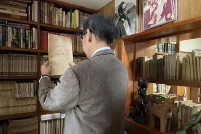 小松左京の書斎で資料を探す、小松の次男実盛さん＝小松左京ライブラリ提供