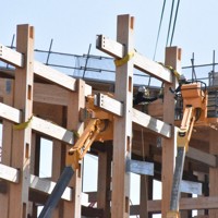 作業員が人の手でクレーンの先と大屋根リングの木材をつなげていた＝大阪市此花区で2026年3月5日午後1時8分、長沼辰哉撮影
