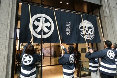 本館中央玄関前にオリジナルのれんを掲げる大丸心斎橋店の従業員ら＝大阪市中央区で2026年3月6日午前9時53分、新宮達撮影