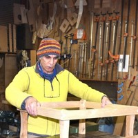 ちゃぶ台を作るダニー・ネフセタイさん。釘は使わず、木を組み合わせるだけで完成させるという＝埼玉県皆野町金沢の「木工房ナガリ家」で2026年3月6日、高木昭午撮影
