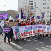 8日、ベルリンで行進する国際女性デーのデモ参加者（共同）