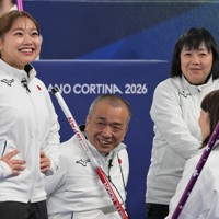 【日本4－10ラトビア】小川亜希（手前右）、中島洋治（奥左）と話し合う荻原詠理コーチ（手前左）＝コルティナ・カーリング五輪競技場で2026年3月9日、渡部直樹撮影