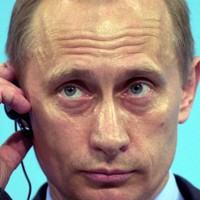 主要8カ国（G8）の九州・沖縄サミットに参加し、記者会見で質問に耳を傾けるロシアのプーチン大統領＝沖縄県名護市で2000年7月23日撮影