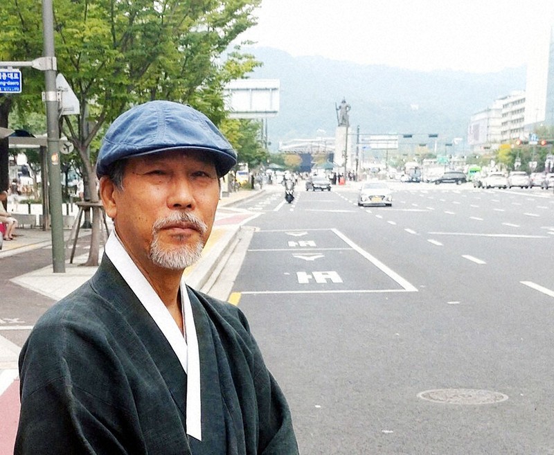 アリラン博士の金煉甲さん。広い道路の先はBTSカムバック公演の舞台、光化門広場だ＝ソウルで2024年9月、鈴木琢磨撮影
