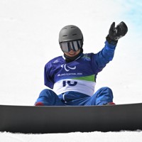 スノーボード男子バンクドスラローム上肢障害、2回目のフィニッシュ時に転倒するも起き上がり手を振る大岩根正隆＝コルティナ・パラスノーボードパークで2026年3月13日、渡部直樹撮影
