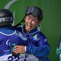 スノーボード男子バンクドスラローム大腿障害、フィニッシュした小栗大地（左）をたたえる小須田潤太＝コルティナ・パラスノーボードパークで2026年3月13日、渡部直樹撮影