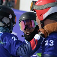 スノーボード男子バンクドスラローム大腿障害、2回目の滑走を終え、他の選手と健闘をたたえあう小栗大地（中央）＝コルティナ・パラスノーボードパークで2026年3月13日、渡部直樹撮影