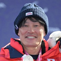 スノーボード男子バンクドスラローム大腿障害で銀メダルを獲得し、表彰式で笑顔を見せる小栗大地＝コルティナ・パラスノーボードパークで2026年3月13日、渡部直樹撮影
