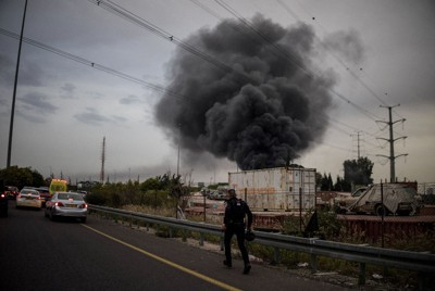 イランのミサイル攻撃による着弾現場に駆け付ける警察官＝イスラエル中部で3月13日、ロイター