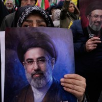 イラン最高指導者のモジタバ師のポスターを掲げ、イスラエルのパレスチナ占領に抗議する女性たち＝首都テヘランで2026年3月13日、AP