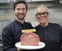 Wolfgang Puck, right, and his son, Byron Lazaroff-Puck, pose with a slab of Miyazaki beef in Los Angeles on March 12, 2026. (Kyodo)