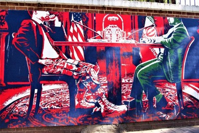 イランとの交渉の席に着いた米側代表（左）の姿が上着はスーツ、ズボンは軍服という壁画。軍事力で相手を威圧する米国の姿を風刺しているとみられる＝テヘランの旧米国大使館前で2021年6月、真野森作撮影