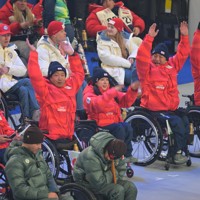 ミラノ・コルティナ冬季パラリンピックの閉会式を前に会場でわき起こったウエーブに合わせて手をあげる村岡桃佳選手（中央）ら日本代表選手団＝コルティナ・カーリング五輪競技場で2026年3月15日午後8時28分、渡部直樹撮影
