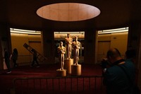 People look on as workers install Oscar statues on March 14, 2026, at the Dolby Theatre in Los Angeles, in preparation for Sunday's 98th Academy Awards ceremony. (AP Photo/Gregory Bull)