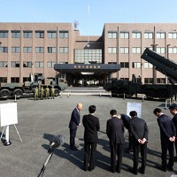 地上発射型の国産ミサイル「12式地対艦誘導弾能力向上型」（奥右）を視察する熊本県知事や熊本市長ら。同左は従来型の「12式地対艦誘導弾」＝熊本市東区の陸上自衛隊健軍駐屯地で2026年3月17日午前9時28分、玉城達郎撮影