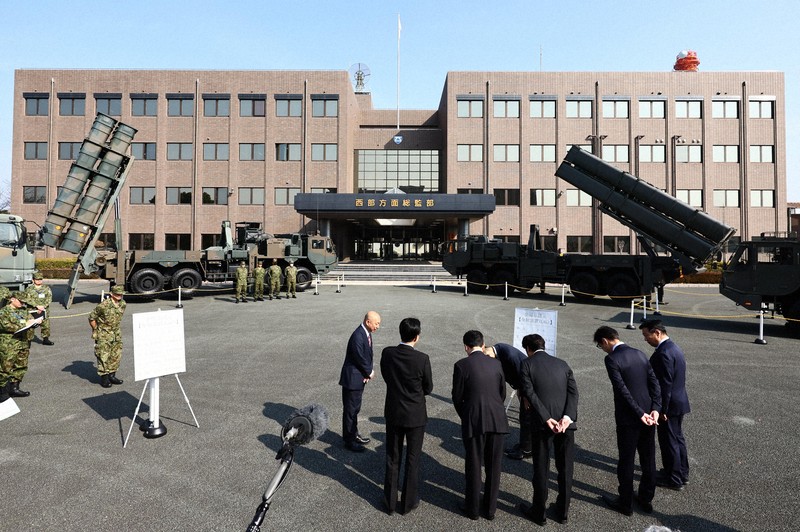 地上発射型の国産ミサイル「12式地対艦誘導弾能力向上型」（奥右）を視察する熊本県知事や熊本市長ら。同左は従来型の「12式地対艦誘導弾」＝熊本市東区の陸上自衛隊健軍駐屯地で2026年3月17日午前9時28分、玉城達郎撮影