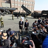 地上発射型の国産ミサイル「12式地対艦誘導弾能力向上型」（中央奥）の視察を終え、報道陣の質問に応じる木村敬熊本県知事（中央左）と大西一史熊本市長＝熊本市東区の陸上自衛隊健軍駐屯地で2026年3月17日午前9時36分、玉城達郎撮影