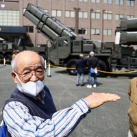 地上発射型の国産ミサイル「12式地対艦誘導弾能力向上型」について記者の質問に答える託麻東校区自治協議会会長の田中穂積さん（左）＝熊本市東区の陸上自衛隊健軍駐屯地で2026年3月17日午後1時26分、玉城達郎撮影
