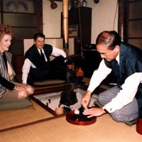 いろりのわきでお茶を立てる中曽根首相を見るレーガン大統領夫妻＝日の出山荘「青雲堂」で　1983年11月11日（代表撮影）