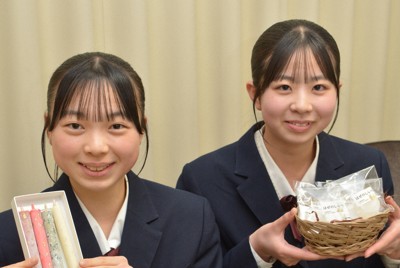 「櫨の可能性は無限大」。櫨を原料とした「シン・和蝋燭」とせっけんを手にする（左から）片山璃奈さん、本田結愛さん＝愛媛県大洲市の大洲農高で2026年3月18日、松倉展人撮影