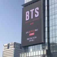 3月21日午後8時からネットフリックスでBTS復帰公演を生中継すると宣伝する電光掲示板＝ソウル市光化門で2026年3月10日、堀山明子撮影