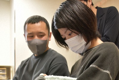 赤ちゃんを抱っこするように遠隔面会用の機器を持つ母親。左は父親＝岩手県北上市の北上済生会病院で2026年3月7日、山田英之撮影