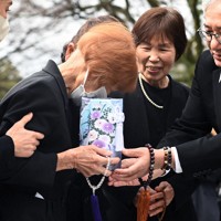 梶山初枝さんの遺骨を手にした妹の大門美智子さん（中央）＝広島市中区で2026年3月22日午前10時16分、佐藤賢二郎撮影