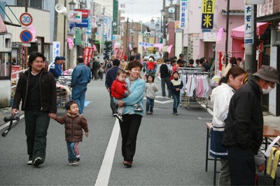 ＜上＞福島県大熊町のJR大野駅前に震災前まであった商店街（2007年4月撮影、町提供）と＜下＞商店街を解体した後に「駅前復興のシンボル」として整備された「CREVAおおくま」＝2026年2月、最上和喜撮影