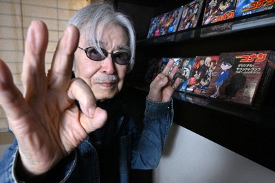 自身が手がけた名探偵コナンのCDを前にポーズをとる作曲家の大野克夫さん＝東京都港区で、西夏生撮影