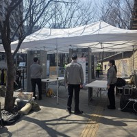 韓国の人気音楽グループBTSの無料コンサートの会場周辺で荷物検査を行う警察ら。金属探知機が設置されている＝ソウルで2026年3月21日午後1時27分、日下部元美撮影