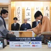初手を指す藤井聡太王将（右）。左は挑戦者の永瀬拓矢九段＝大阪府高槻市の関西将棋会館で