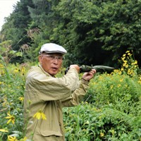 猟銃所持の許可を取り消されるきっかけとなった現場で射撃を再現する池上治男さん。当時は茂みが開けていた＝北海道砂川市で2025年8月20日午後4時45分、後藤佳怜撮影