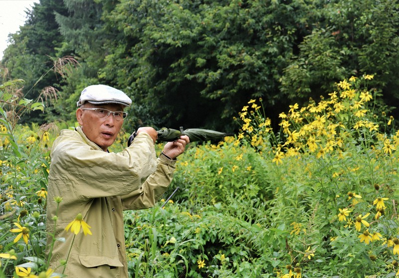 猟銃所持の許可を取り消されるきっかけとなった現場で射撃を再現する池上治男さん。当時は茂みが開けていた＝北海道砂川市で2025年8月20日午後4時45分、後藤佳怜撮影