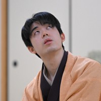 立会の桐山清澄九段（手前右）に封じ手を渡す挑戦者の永瀬拓矢九段（手前左）。奥右は藤井聡太王将＝大阪府高槻市の関西将棋会館で2026年3月25日午後6時8分、西村剛撮影