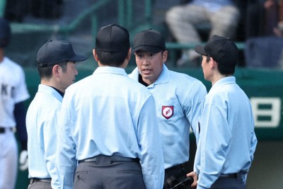 【大阪桐蔭－三重】八回裏三重1死二、三塁、打者・大西新史の時、スクイズの構えからボールが体に当たり、三塁走者の生還が認められたプレーについて協議する審判団＝阪神甲子園球場で2026年3月26日、玉城達郎撮影
