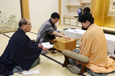 藤井聡太王将（右）に封じ手を見せる立会の桐山清澄九段（左）。中央は封じ手を指す永瀬拓矢九段＝大阪府高槻市の関西将棋会館で2026年3月26日午前8時58分、西村剛撮影