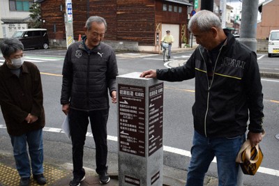 設置したばかりの道標を見る中辻重行部会長（中央）ら。中央奥が初瀬街道＝名張市松崎町で
