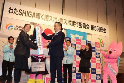 国スポ・障スポのレガシーとして「する」「見る」「支える」のメッセージたすきを県高校生活動推進委員に渡す三日月大造知事（手前右）＝大津市のホテルで、岸桂子撮影