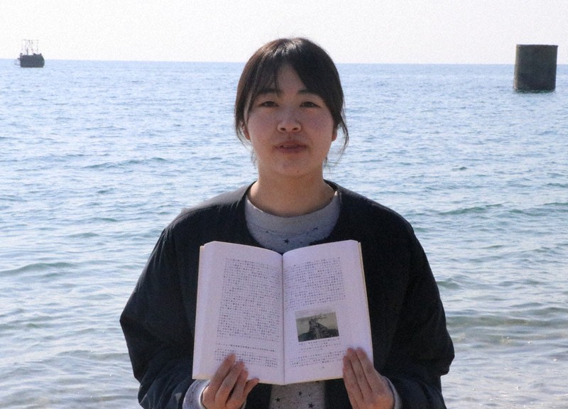 長生炭鉱をテーマに卒論を書いた古都紫苑さん。この1年でピーヤ（後方）を見る目も変わった＝山口県宇部市西岐波の床波海岸で2026年3月21日午前9時30分、綿貫洋撮影