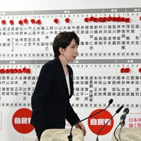 自民党開票センターでテレビ中継のインタビューを終え、候補者の名前に多くの花がつく掲示板の前を歩く高市早苗首相＝同党本部で2026年2月8日午後10時26分、平田明浩撮影