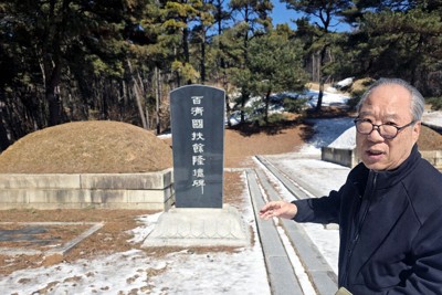 百済の隆王子の墓地と石碑について説明する徐龍植さん＝韓国西部・扶余郡で2月25日、福岡静哉撮影