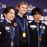 表彰式後の記者会見で記念撮影する（左から）2位の鍵山優真、1位で米国のイリア・マリニン、3位の佐藤駿＝プラハ・O2アリーナで2026年3月28日、滝川大貴撮影