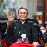 「お練り」で人力車に乗り、集まったファンの声援に応える片岡仁左衛門＝大阪市中央区で2026年3月29日、村田貴司撮影