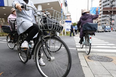 信号の前で一時停止する自転車の利用者（手前）＝東京都墨田区で2026年3月27日午前10時11分、後藤由耶撮影